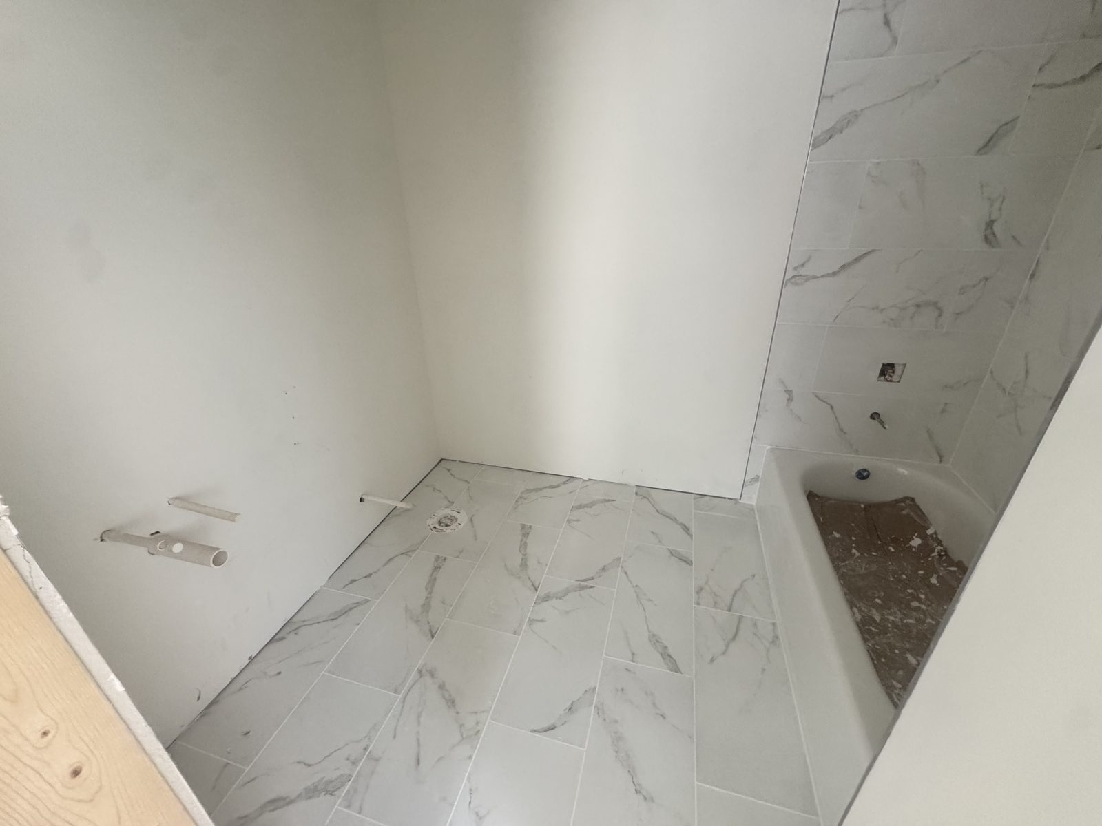 Completed tub surround and floor tilework in a Gainesville Apartments unit bathroom